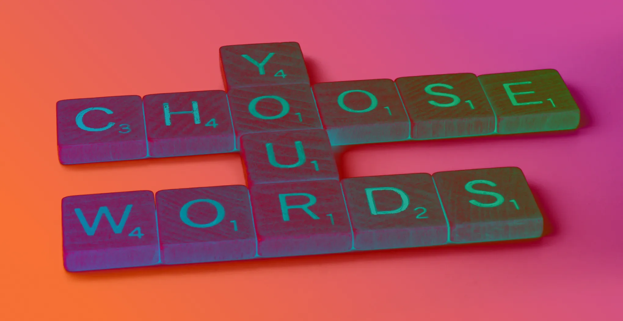 Some scrabble tiles spelling out the phrase 'Choose Your Words'.